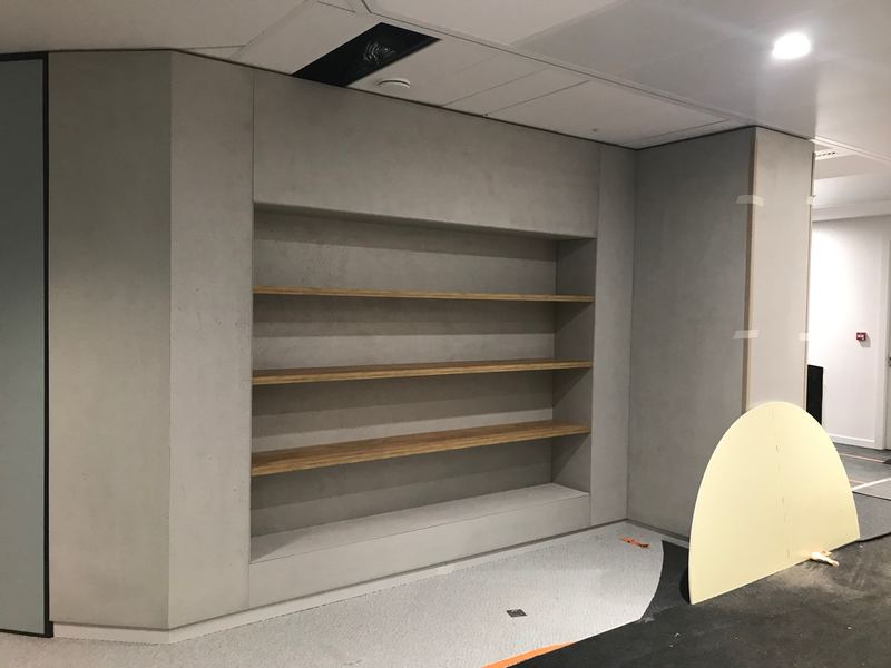 Coin café habillé de panneaux effet béton, niches et étagères en bois