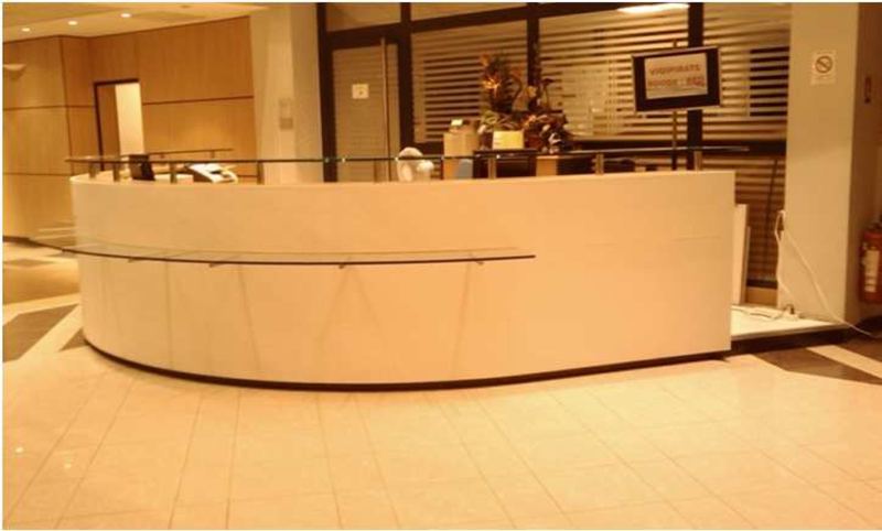 Banque d'accueil courbe en bois clair dans un hall