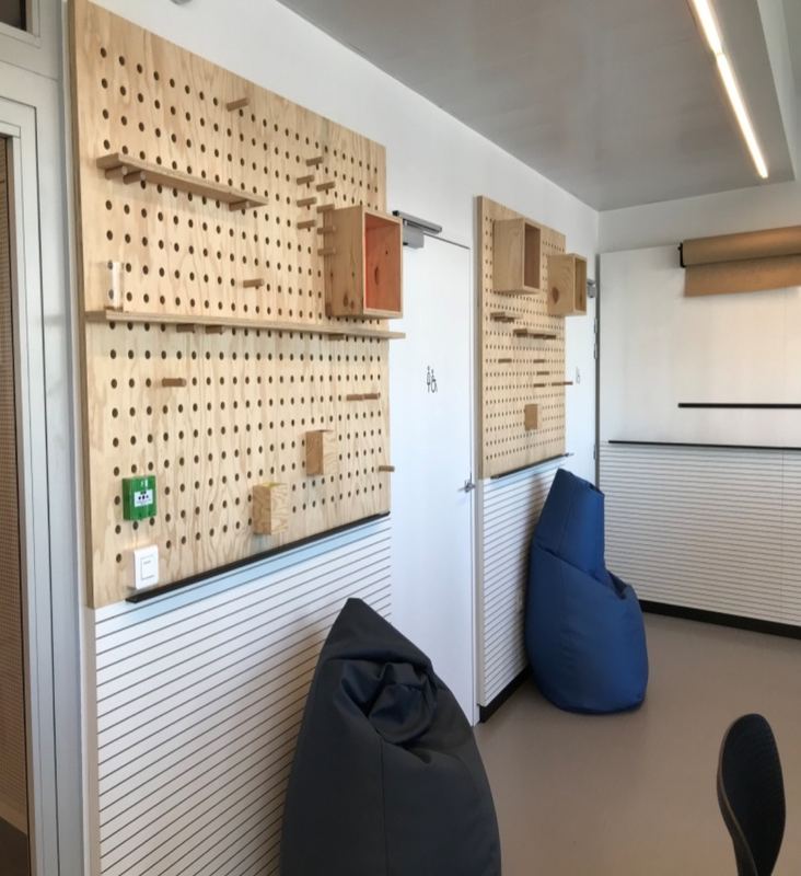 Panneaux de présentation perforés en bois dans un espace de bureaux