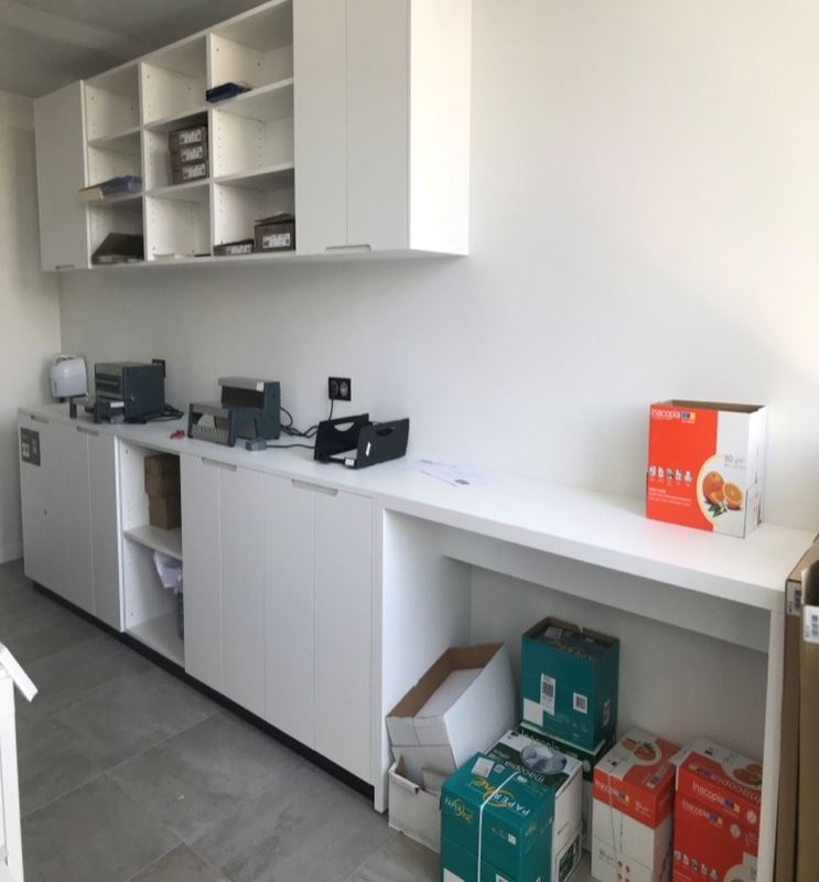 Salle de reprographie avec plans de travail et rangements blancs